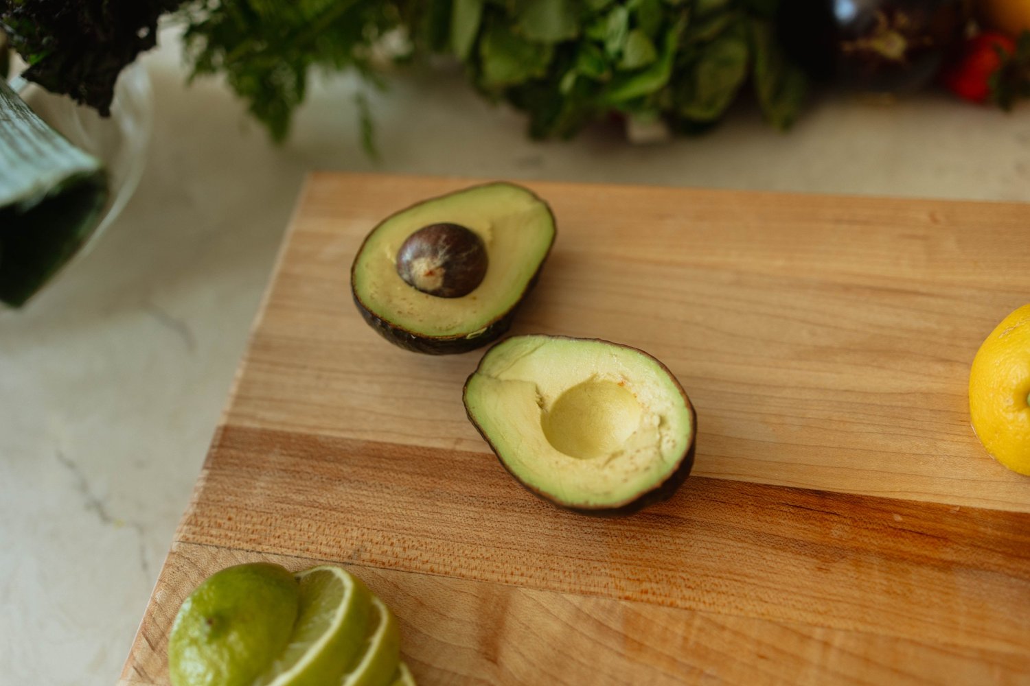 Fresh avocado and citrus on a kitchen cutting board